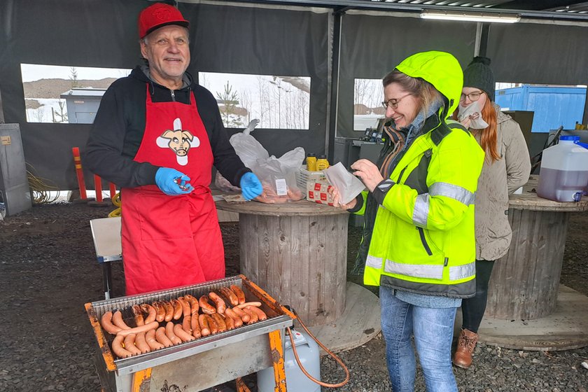 Mies tarjoilee grillimakkaraa TAKKin Loistoduunissa.