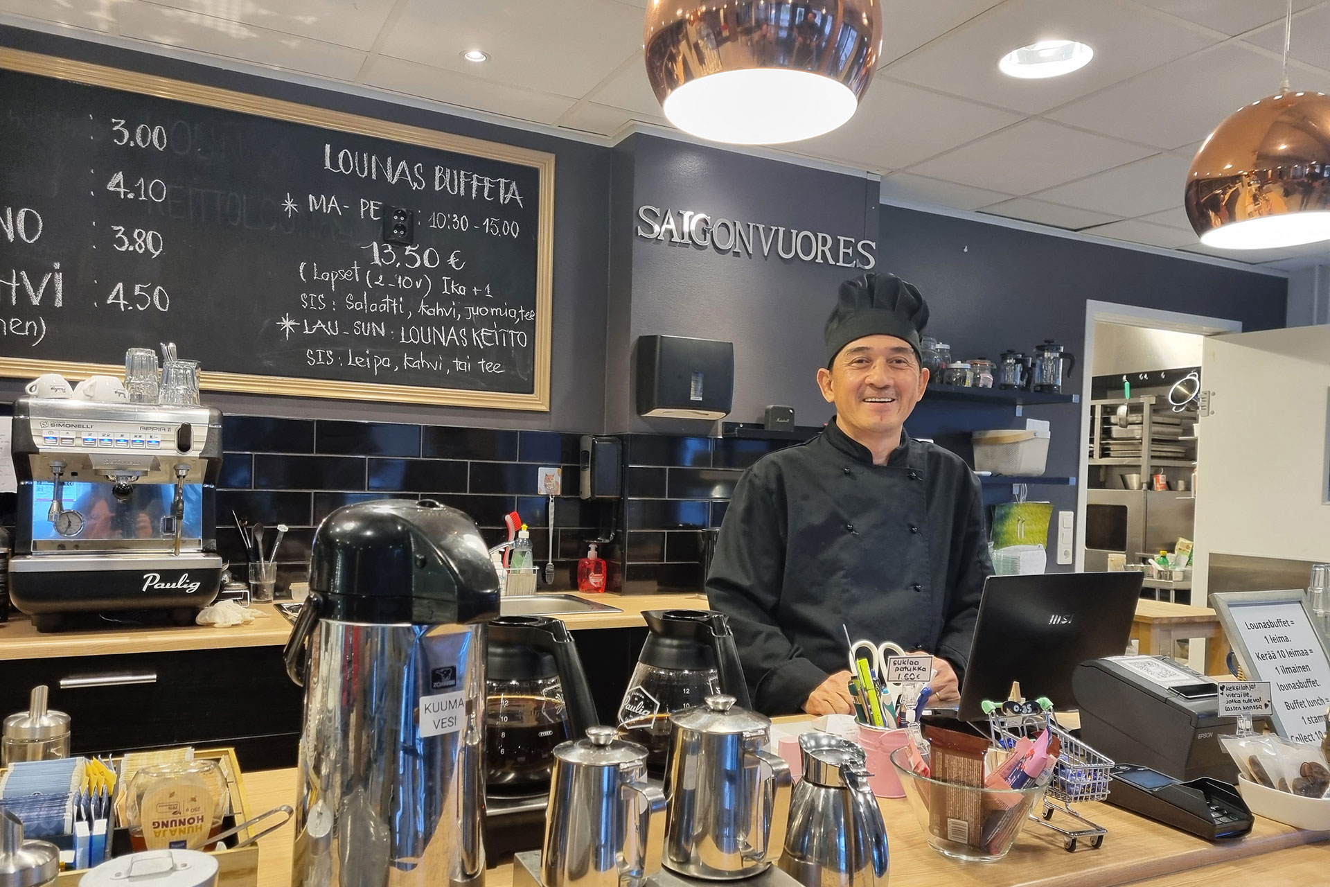 Vincenth is standing behind the restaurant counter, smiling.